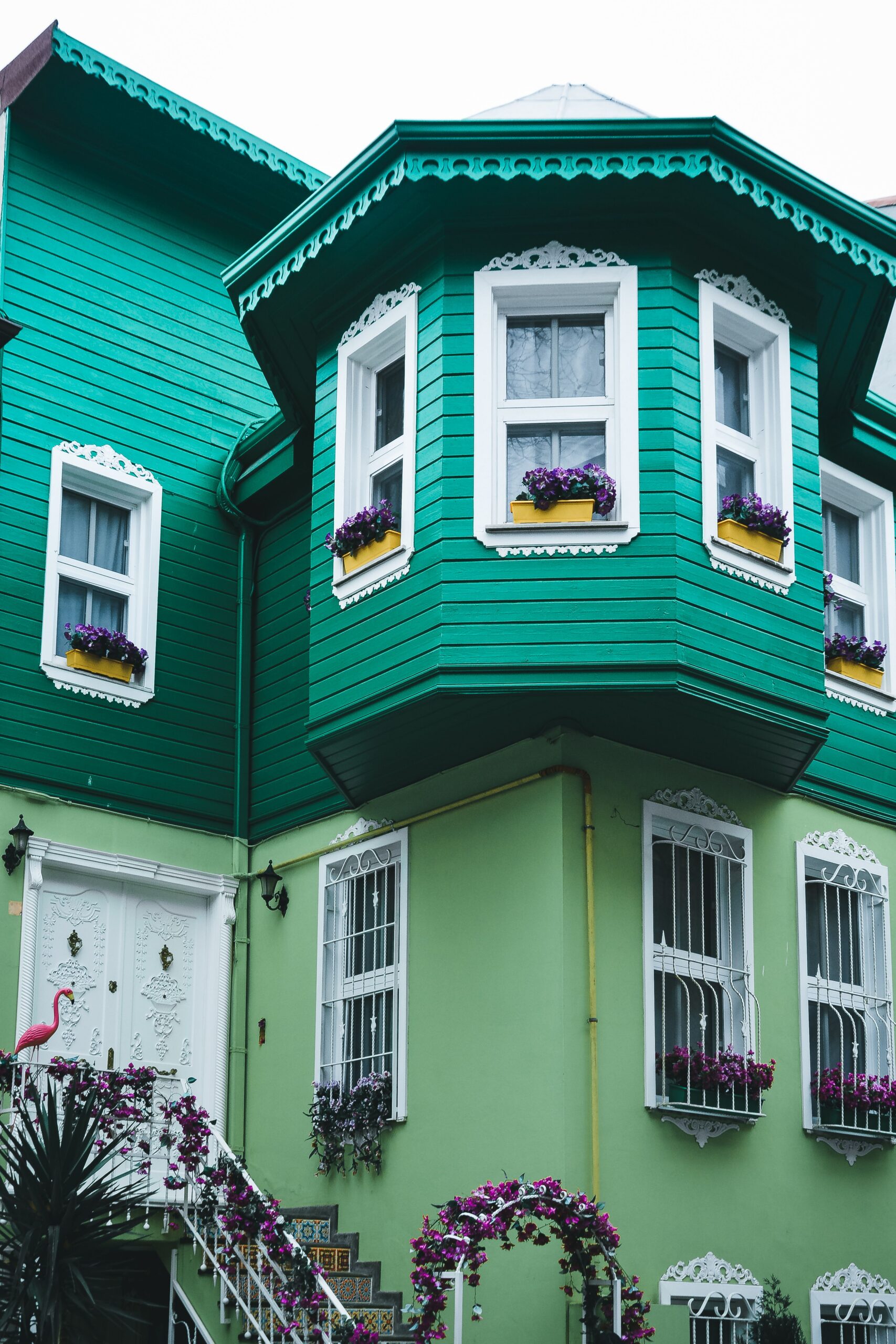 Exterior façade painting in green on a Victorian-style house