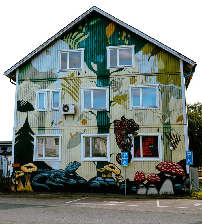 services-02 Vibrant urban mural covers building facade with nature-inspired art and creatures.